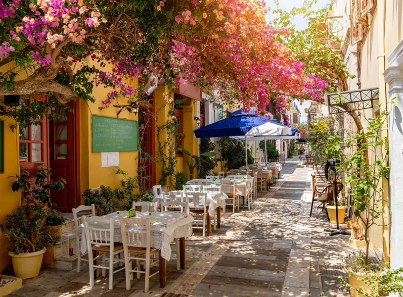 Restaurant in flower covered street in the beautiful Greek town of Nafplio, Greece.