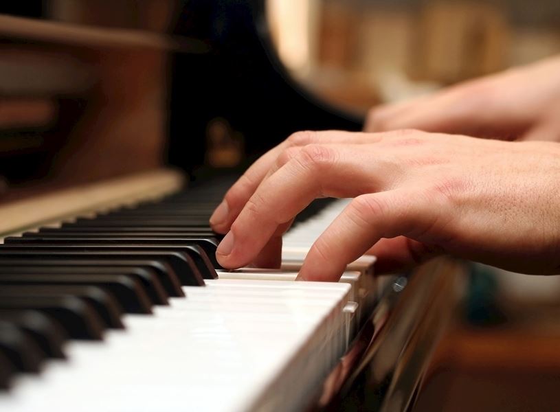 Close-up of hands playing piano keys in Salzburg, Austria