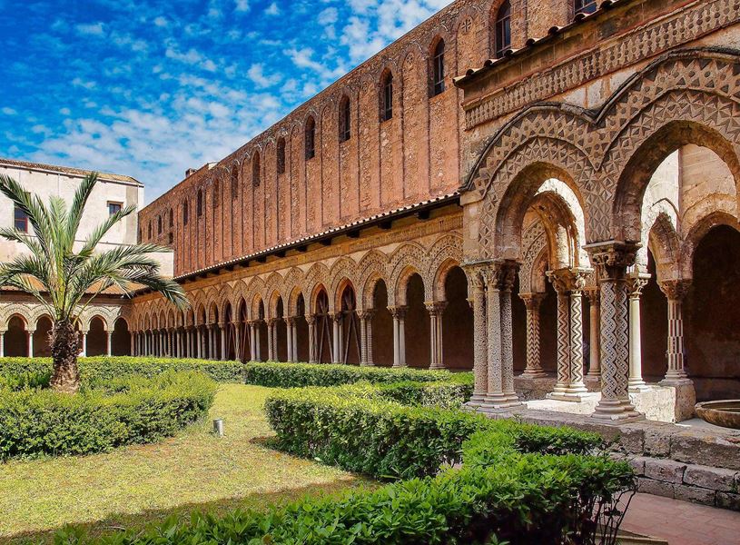 Ornate arches and courtyard garden of Cathedral of Monreale in Sicily