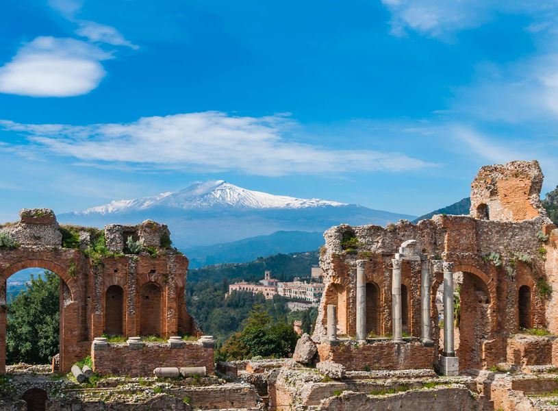 Ancient Greek theatre ruins with Mount Etna snow-capped in Taormina