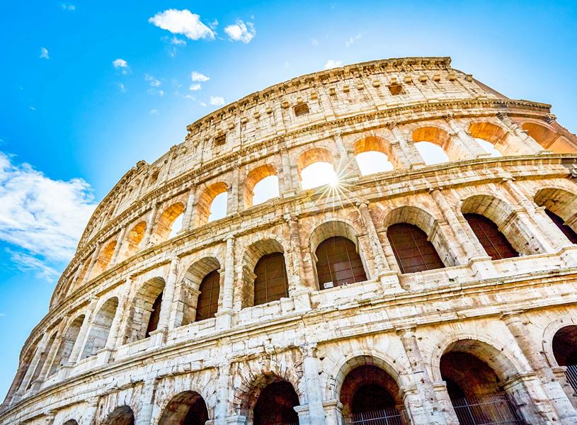 Colosseum in Rome with bright sunburst through arches