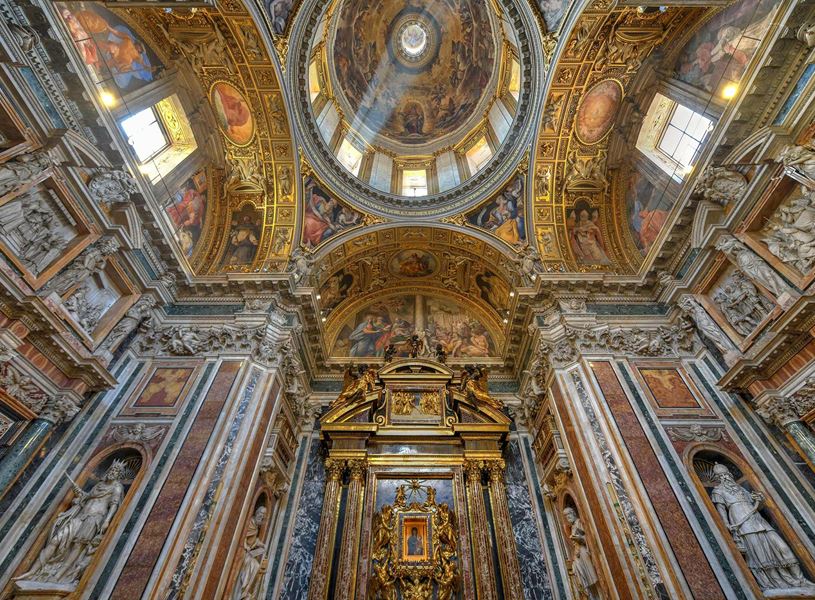 Interior of Basilica di Santa Maria Maggiore in Rome with gilded dome and frescoes.