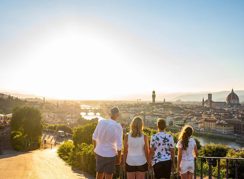 Family overlooking Florence skyline with Duomo and Arno River at sunset