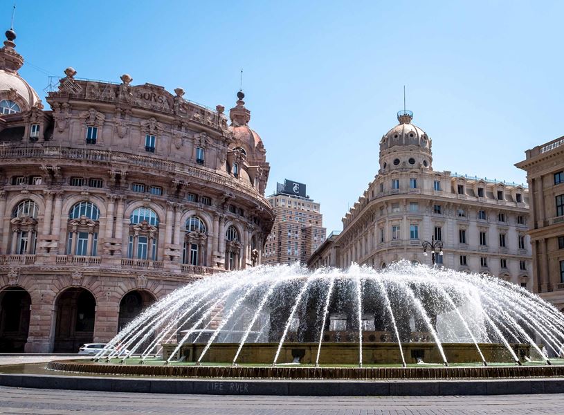 Fountain in Piazza De Ferrari surrounded by historic buildings in Genoa