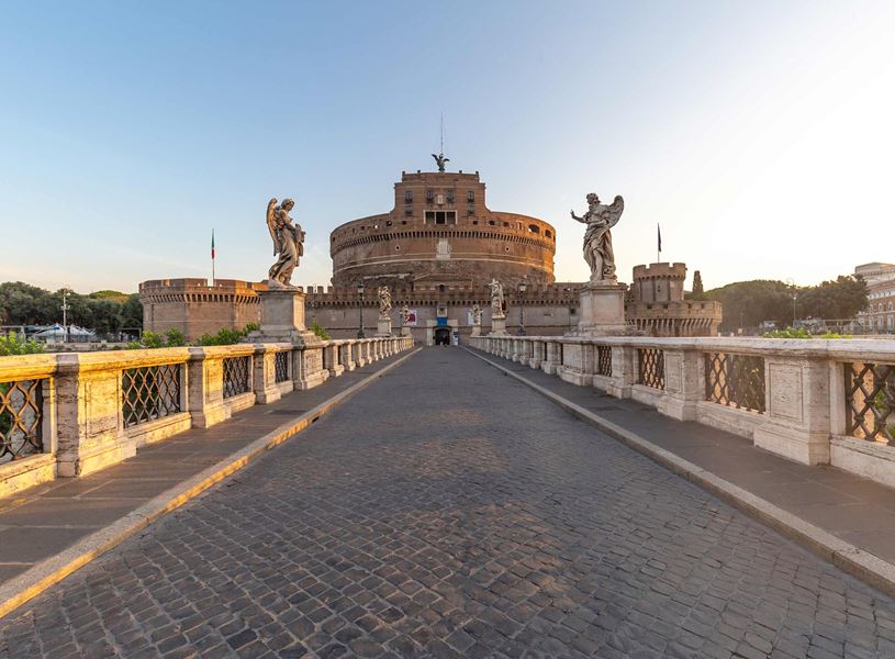 Bridge leading to Castel Sant’Angelo with marble statues and cobblestone walkway in Rome