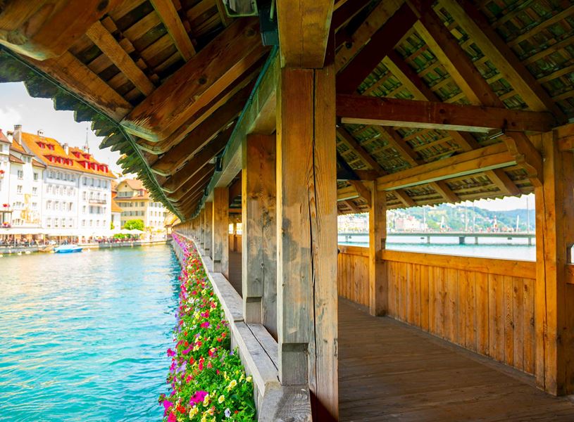 Covered Chapel Bridge decorated with flowers over Reuss River in Lucerne, Switzerland