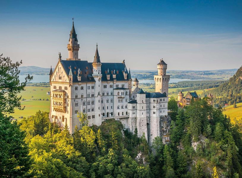 Neuschwanstein Castle on forested hilltop and scenic landscape