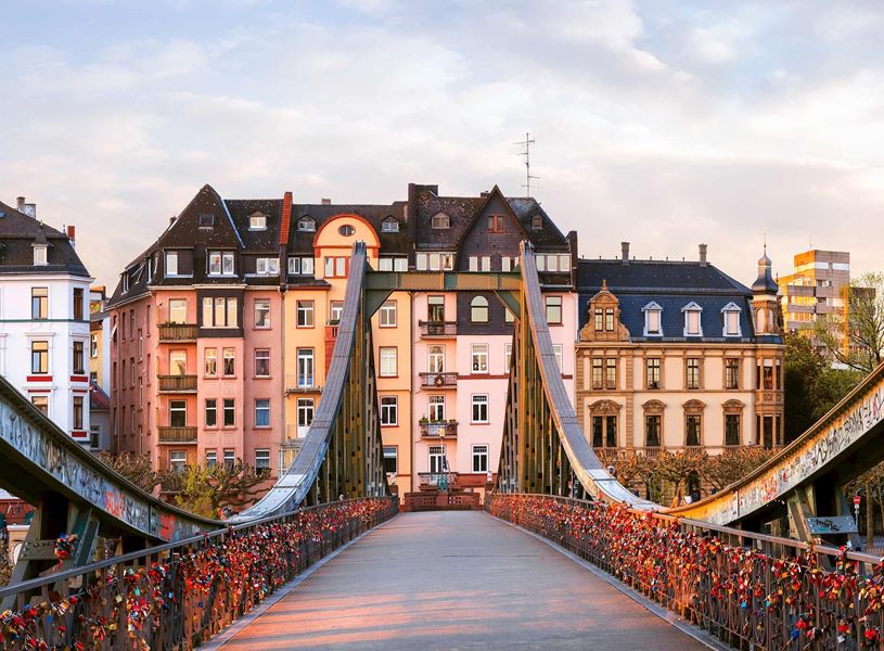 Eiserner Steg bridge with love locks and city backdrop in Frankfurt