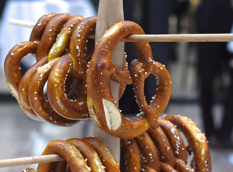 Pretzels with salt crystals stacked on wooden rods 