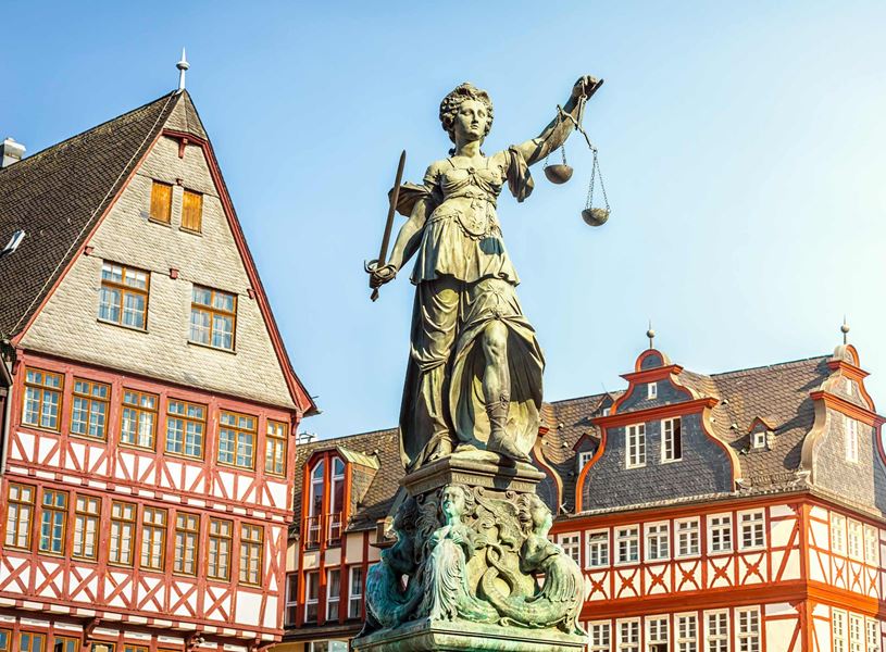 Lady Justice statue with historic half-timbered buildings in Frankfurt