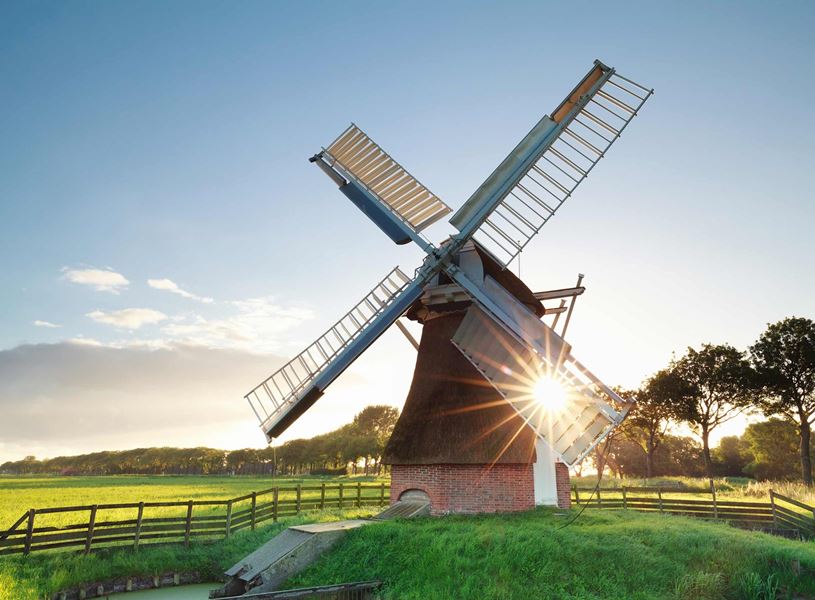 Traditional Dutch windmill standing in green field