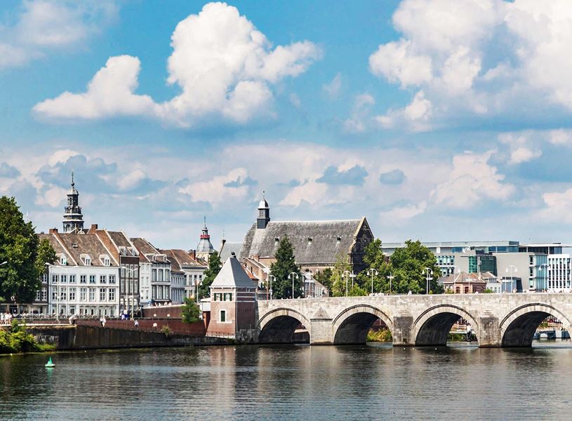 Historic stone bridge over river in Maastricht cityscape