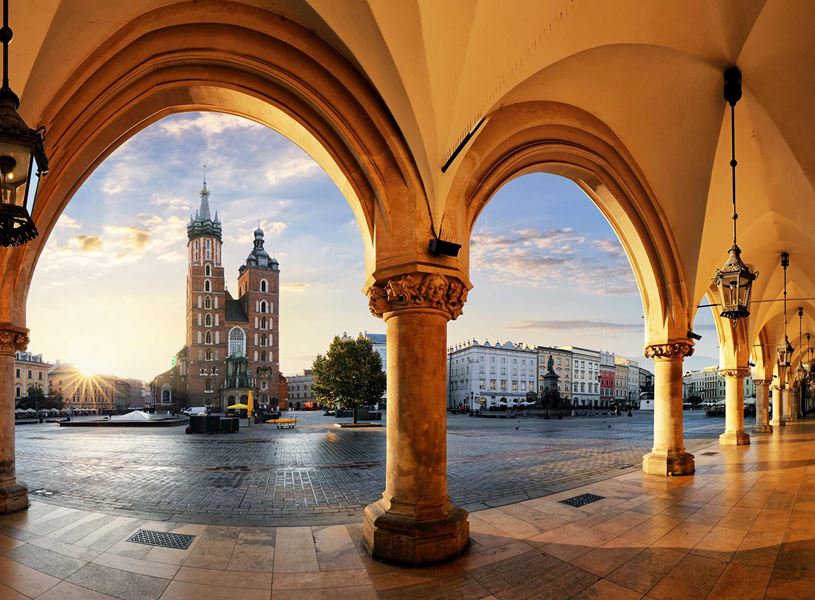 St. Mary’s Basilica framed by Cloth Hall arches at sunrise in Kraków, Poland