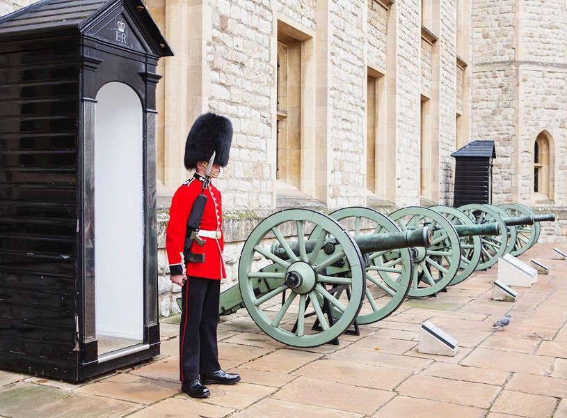 Guard beside sentry box and cannons at Tower of London, England
