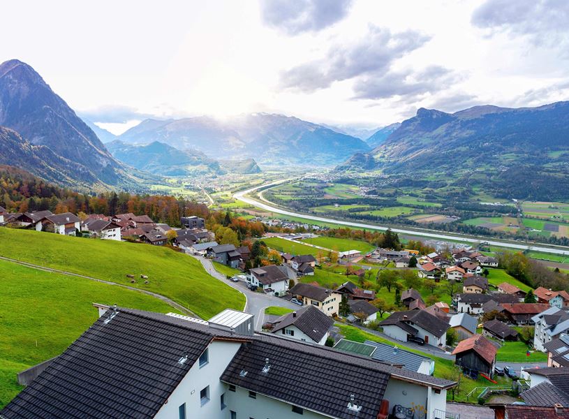 Aerial view of Triesenberg village in Liechtenstein with alpine houses, meadows and River Rhine