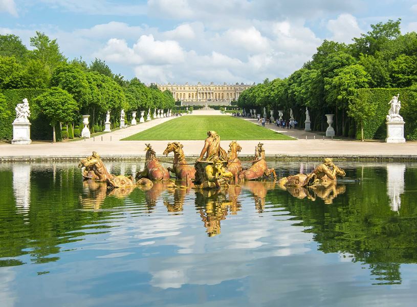 Fountain of Apollo at Versailles with chariot sculpture and tree-lined lawn
