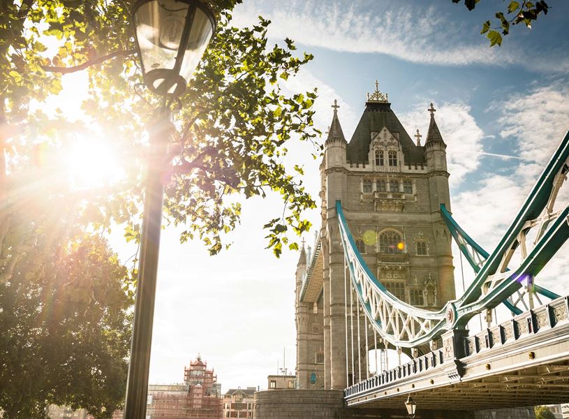 Tower Bridge with trees and bright morning sunlight in London