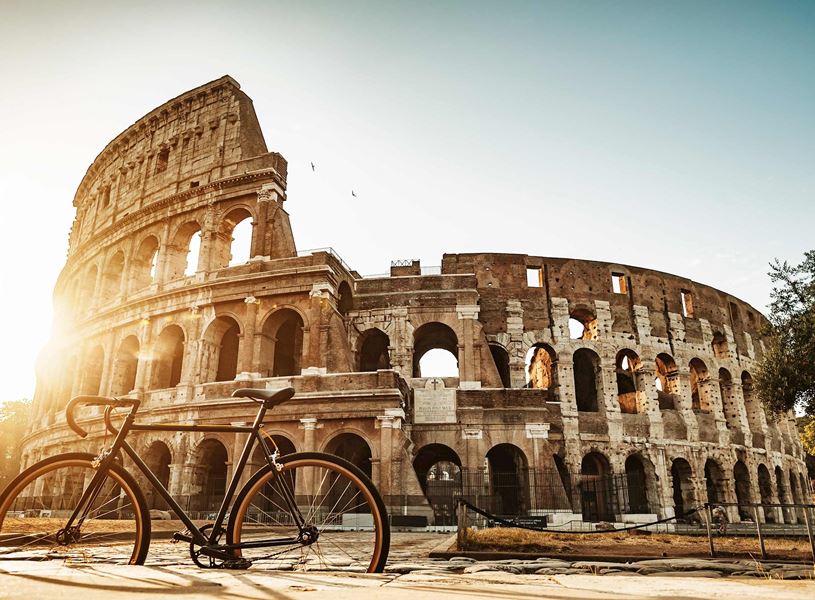 Bicycle parked in front of Colosseum in Rome at sunrise 