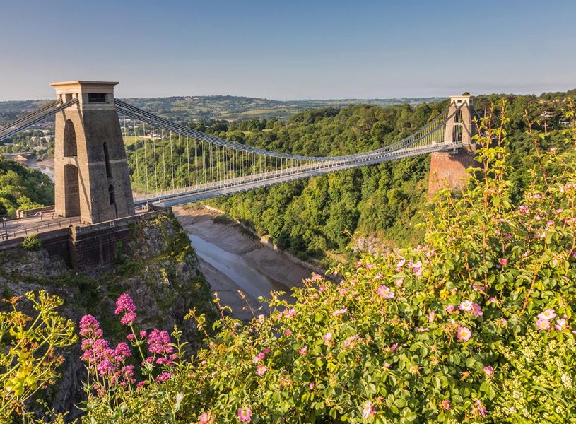 Clifton Suspension Bridge over gorge with flowers and blue sky in Bristol, England