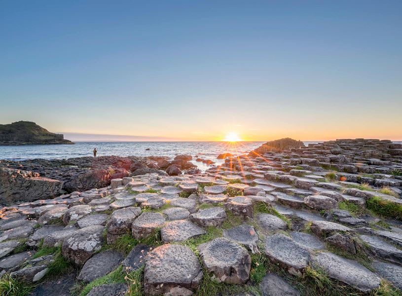 Giant’s Causeway basalt columns with green moss at sunset