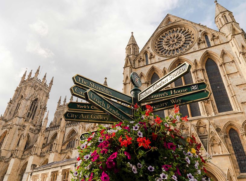 York Minster with signpost and colourful flower display in England