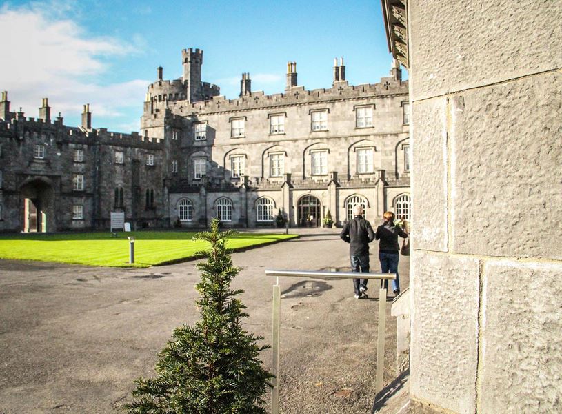 Kilkenny Castle with towers, arched windows and visitors