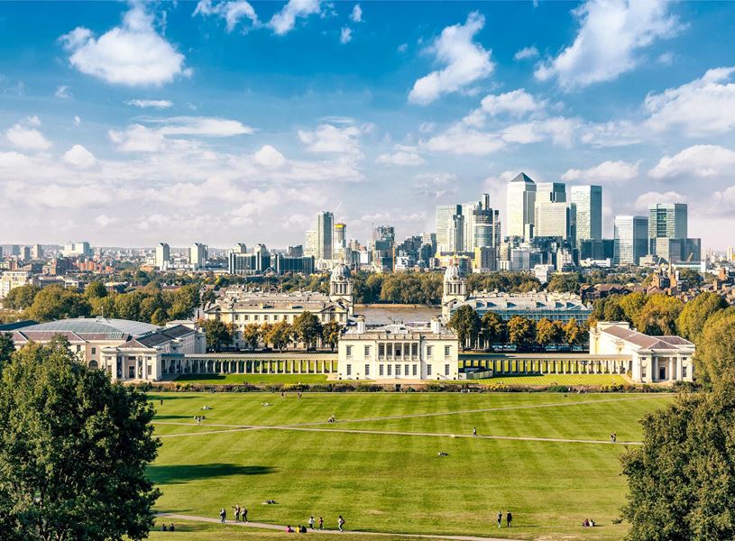 Greenwich Park lawn with college buildings and London skyline in background