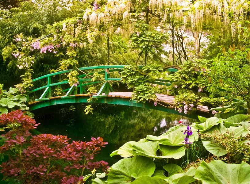 Green arched bridge in Monet’s Garden surrounded by foliage in Giverny, France