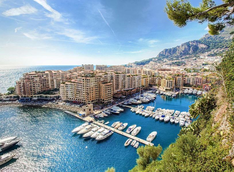 Fontvieille harbour with yachts, cityscape and mountain backdrop in Monaco