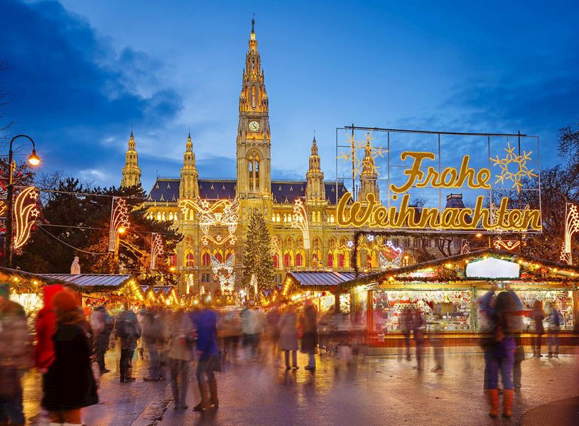 Christmas market and Frohe Weihnachten sign in front of Rathaus City hall in Vienna, Austria