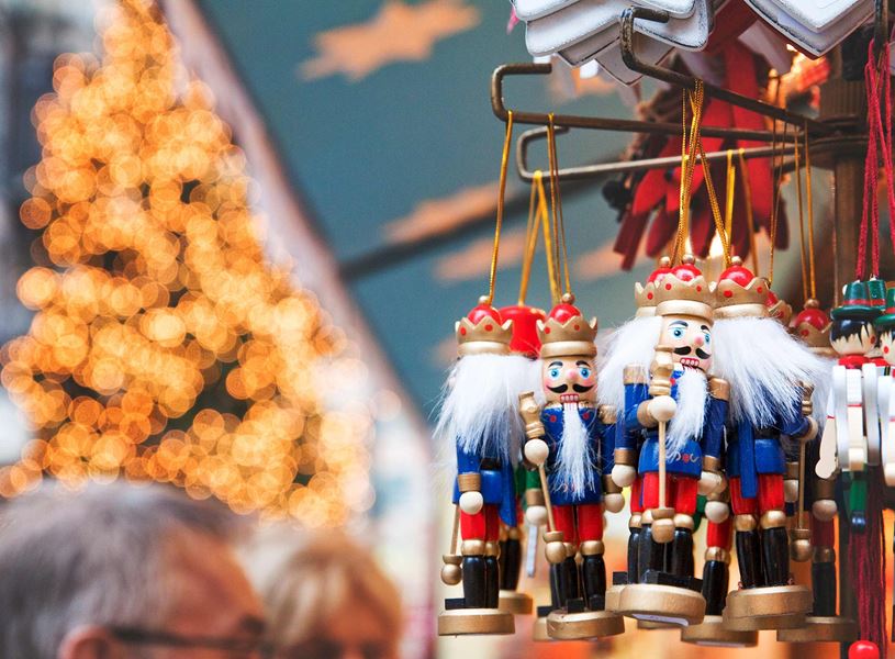 Hanging nutcracker ornaments with festive lights at Christmas market display