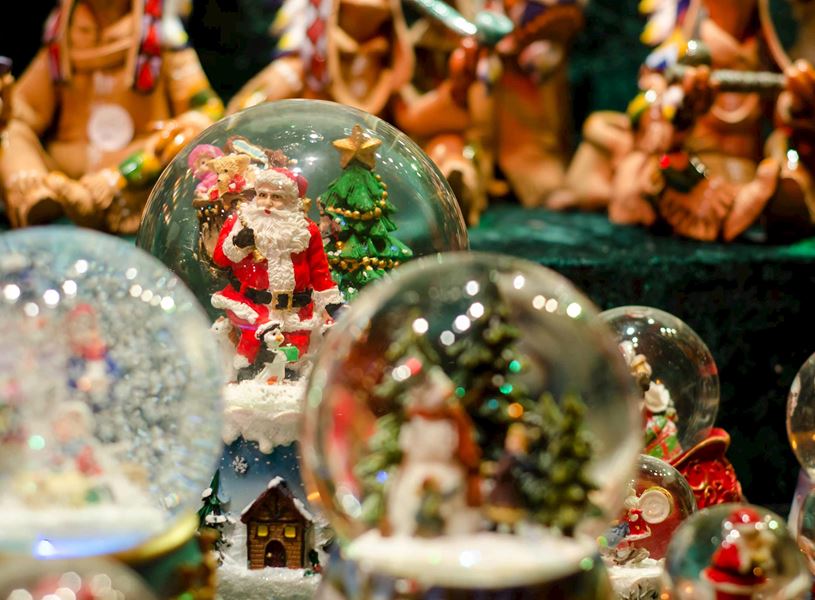 Christmas snow globes with Santa, trees and festive figurines on display