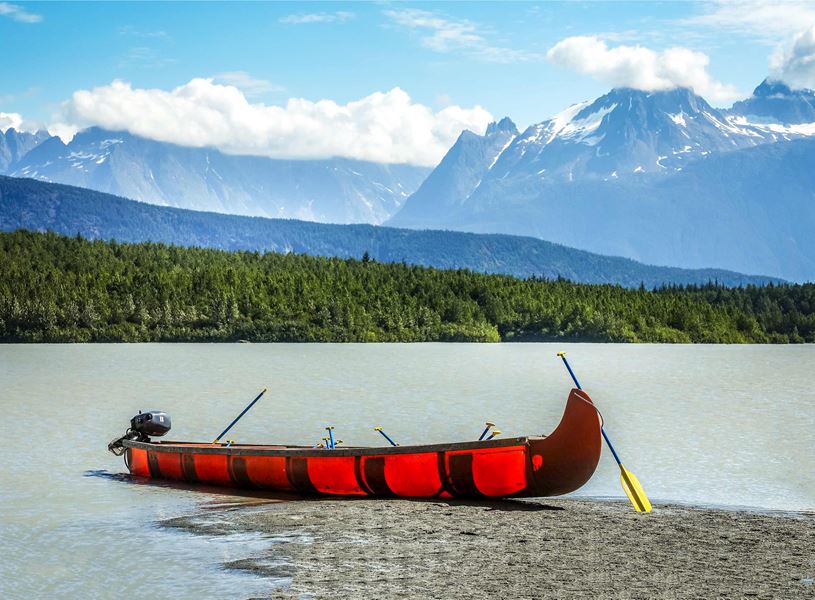 Red canoe accompanied by mountainous landscape in Anchorage, Alaska, USA