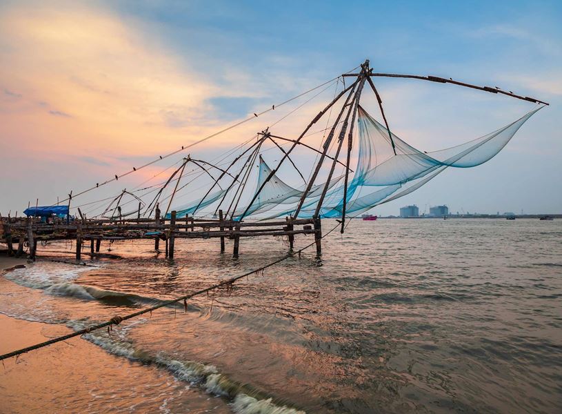 Fishing nets in Kochi under sunset slkies, Kerala