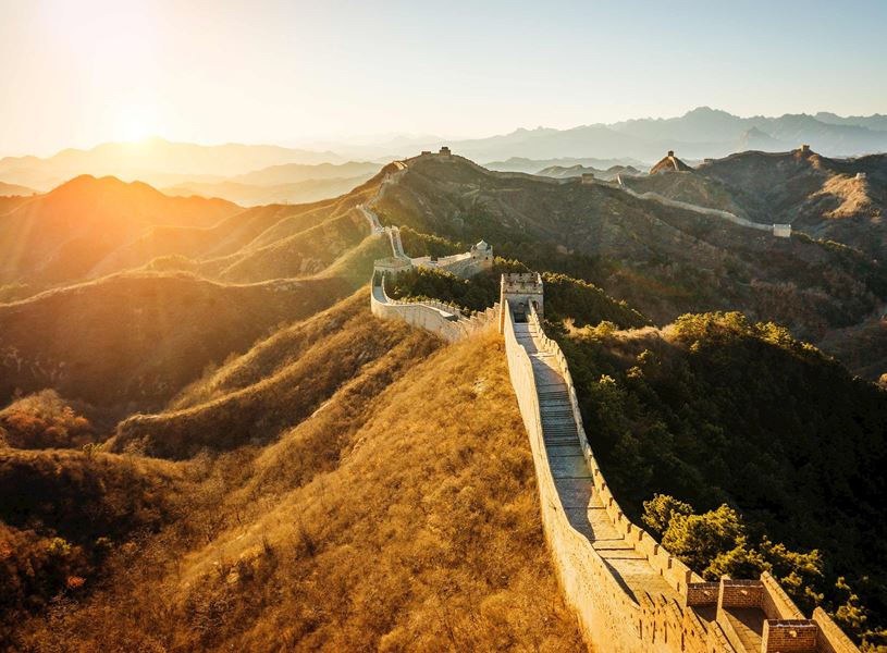 Golden sunlight illuminating aerial view of Great Wall, Beijing, China
