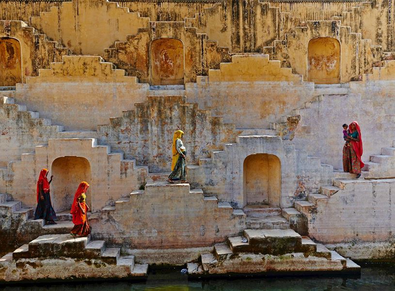 Locals in traditional Rajasthani clothes near rainwater tank, Jaipur, India