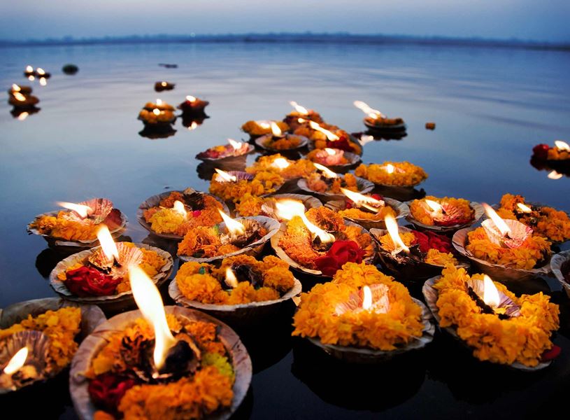 Devotional oil lamps on Ganges River during sunrise ceremony, Varanasi, India