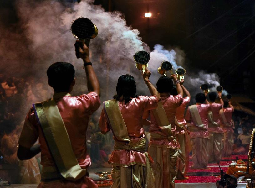 Priests performing Aarti ritual viewed from behind in Varanasi, India
