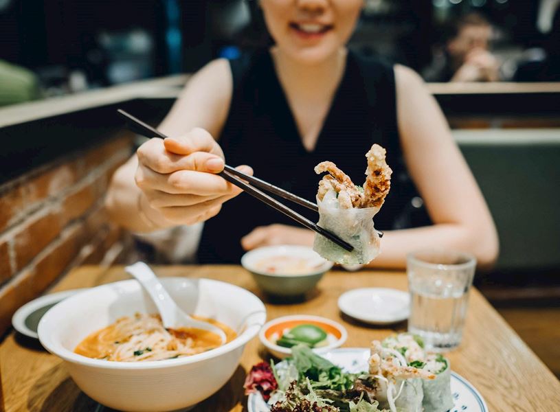 Woman eating food in Hoi An, Vietnam