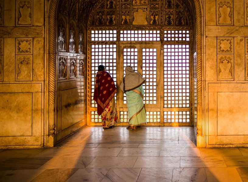 Back view of women in saris admiring view from Agra Fort, India