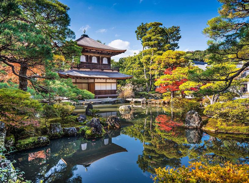 Temple of the Silver Pavilion surrounded by lush gardens and reflective pond in Kyoto, Japan