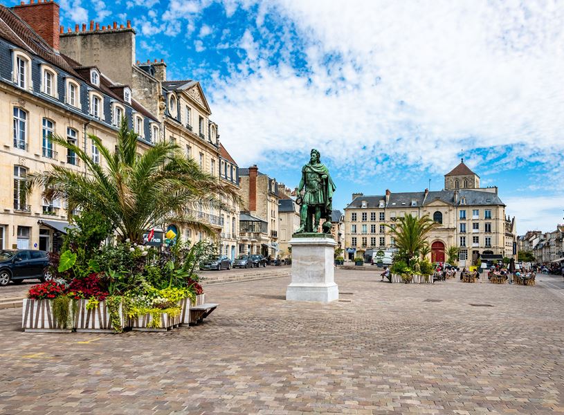 Historic square with statue, flowers and classic architecture in n Caen, France