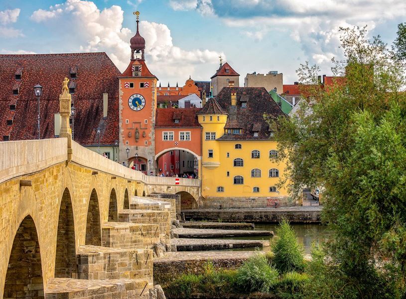Stone Bridge with buildings and clock tower in Regensburg