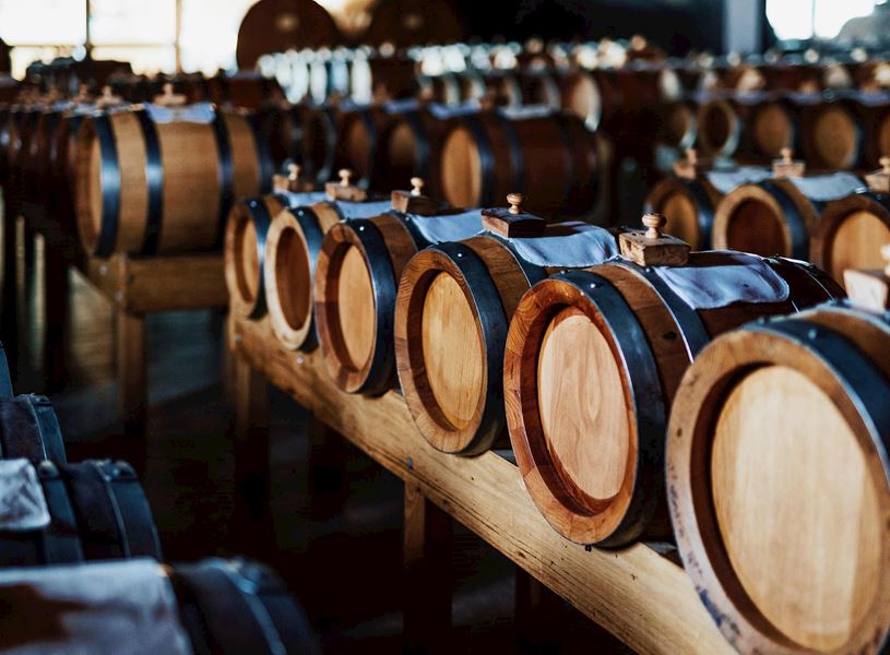 Rows of wooden barrels aging traditional balsamic vinegar in Modena cellar