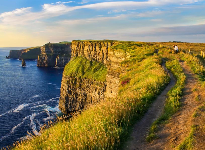 Cliffs of Moher with Atlantic Ocean view and walking path along grassy edge