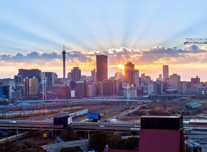 Johannesburg cityscape at sunrise with busy highway and skyline