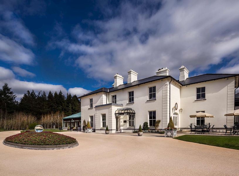 Lodge at Ashford Castle with white facade, gardens and outdoor seating in Cong