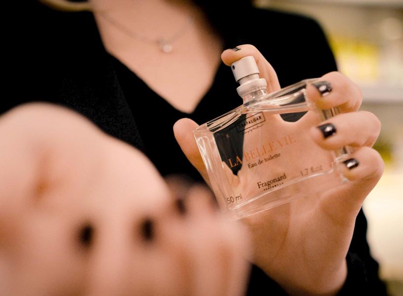 Close-up of hand spraying perfume bottle