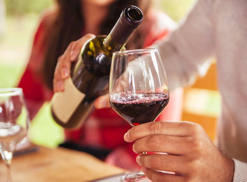 Traveller pouring red wine into glass