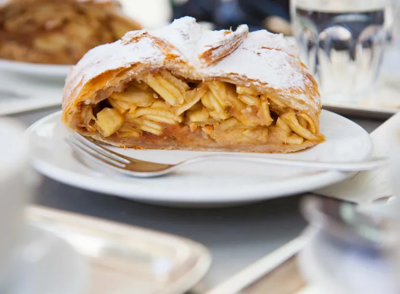 A slice of apple strudel on a white plate in Vienna, Austria